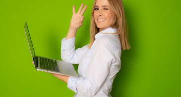 portrait-dune-jeune-femme-daffaires-tenant-un-ordinateur-portable-argenté-dans-le-bureau